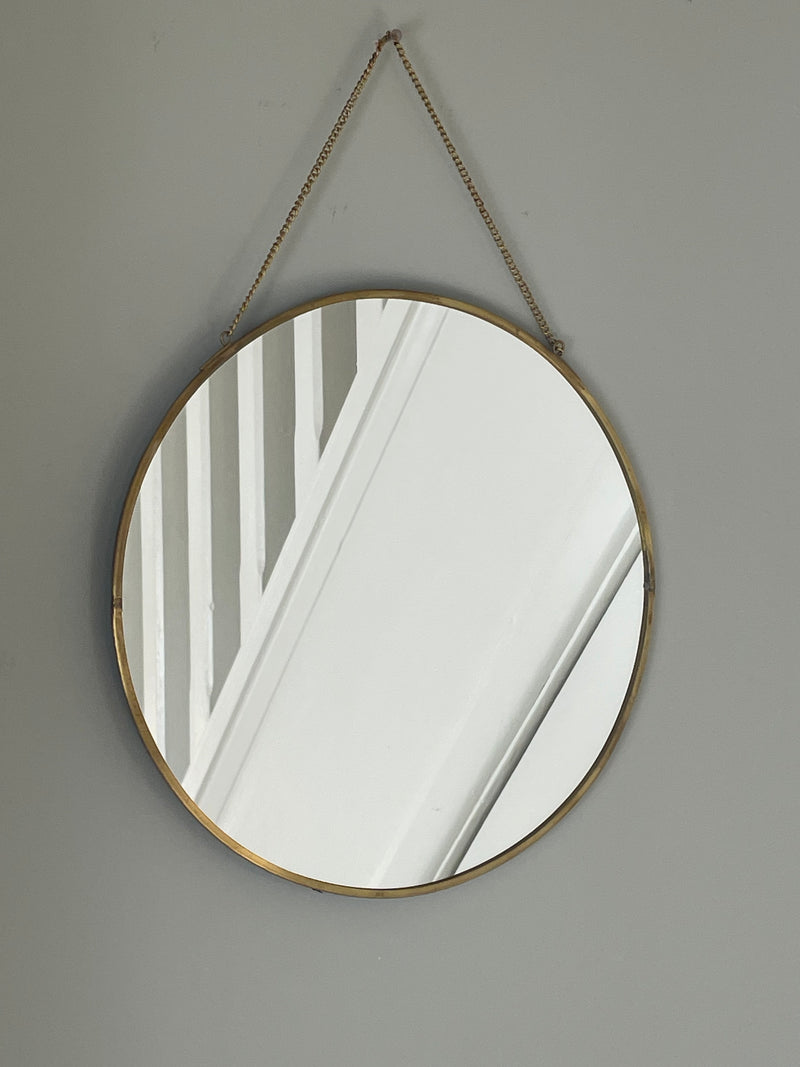 Black round mirror with gold accent and fob detail