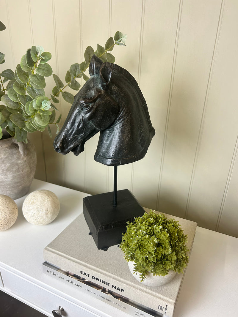 Black carved horse head on base stand