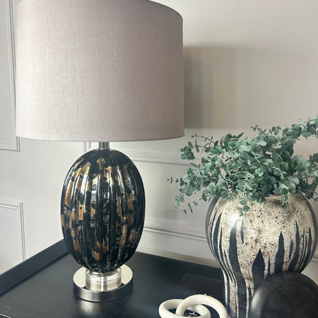 Black and gold glass lamp with taupe shade