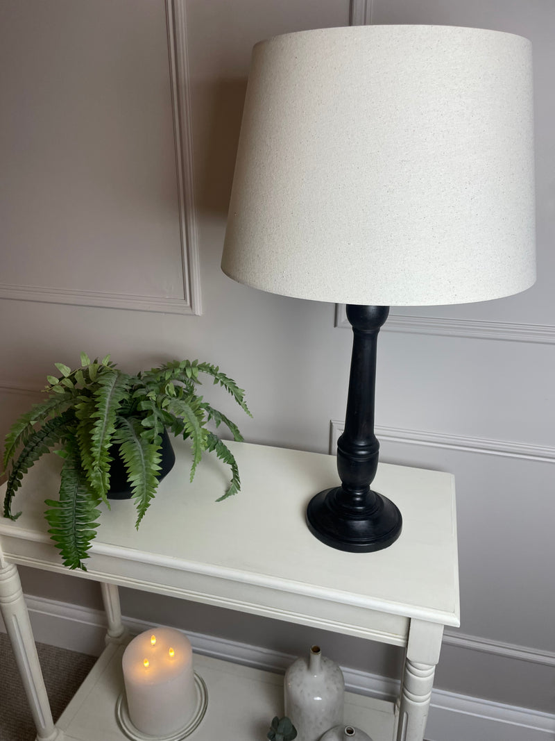 Black wooden turned lamp with linen shade