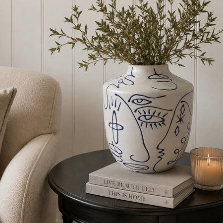 White blue ceramic faces vase