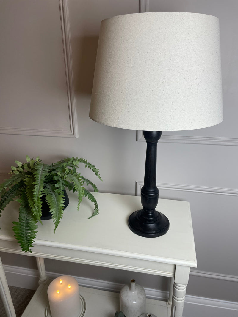Black wooden turned lamp with linen shade