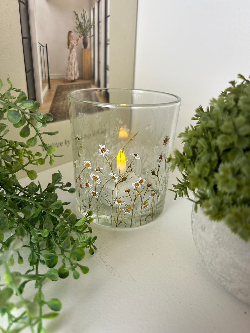 Round glass candle holder filled with dried flowers