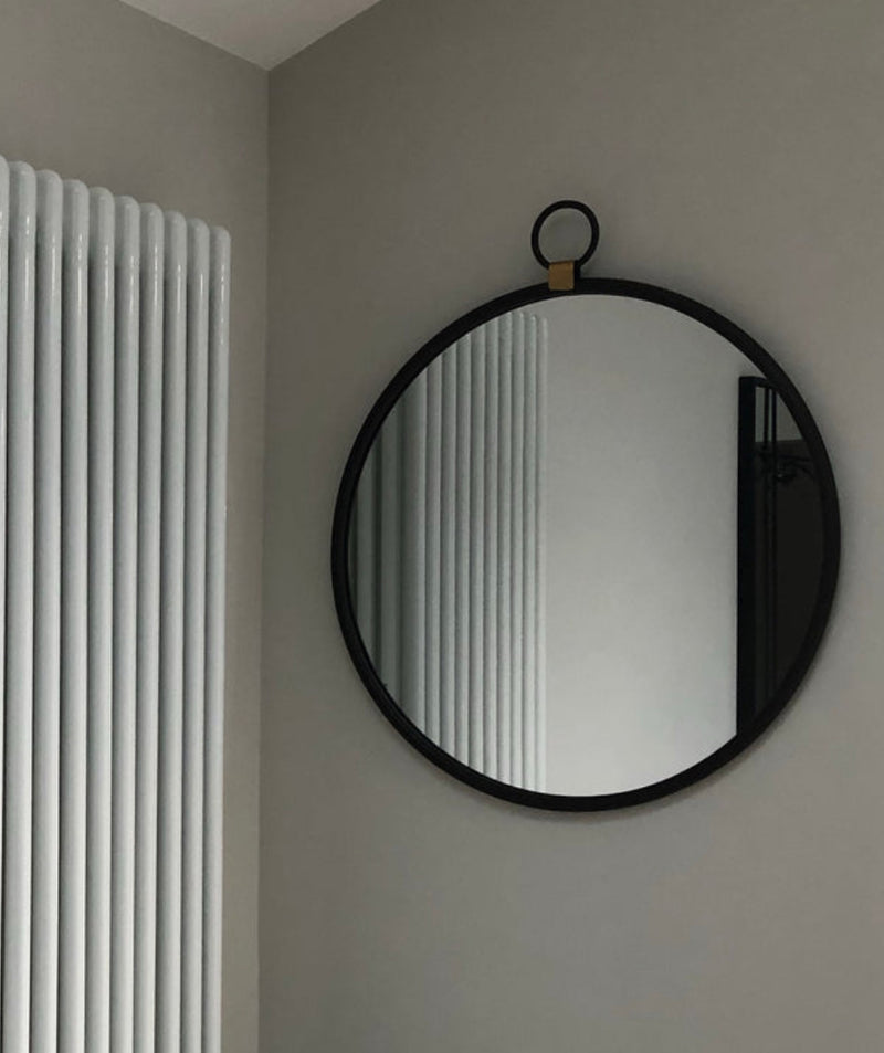 Black round mirror with gold accent and fob detail