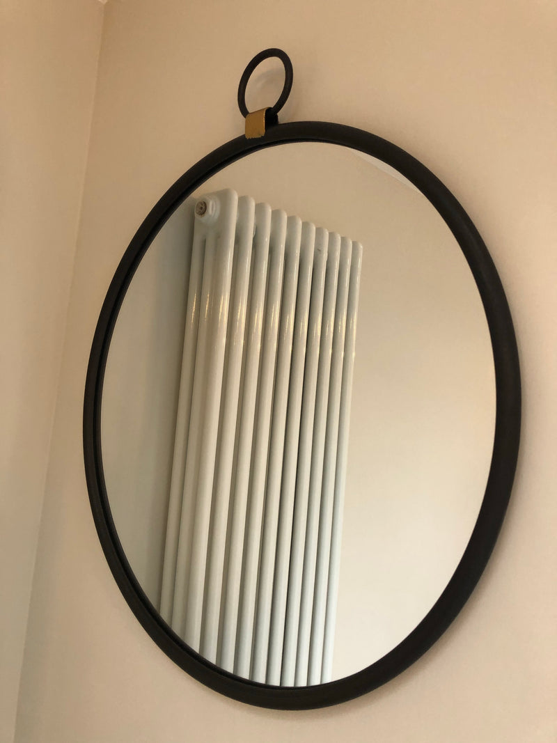 Black round mirror with gold accent and fob detail