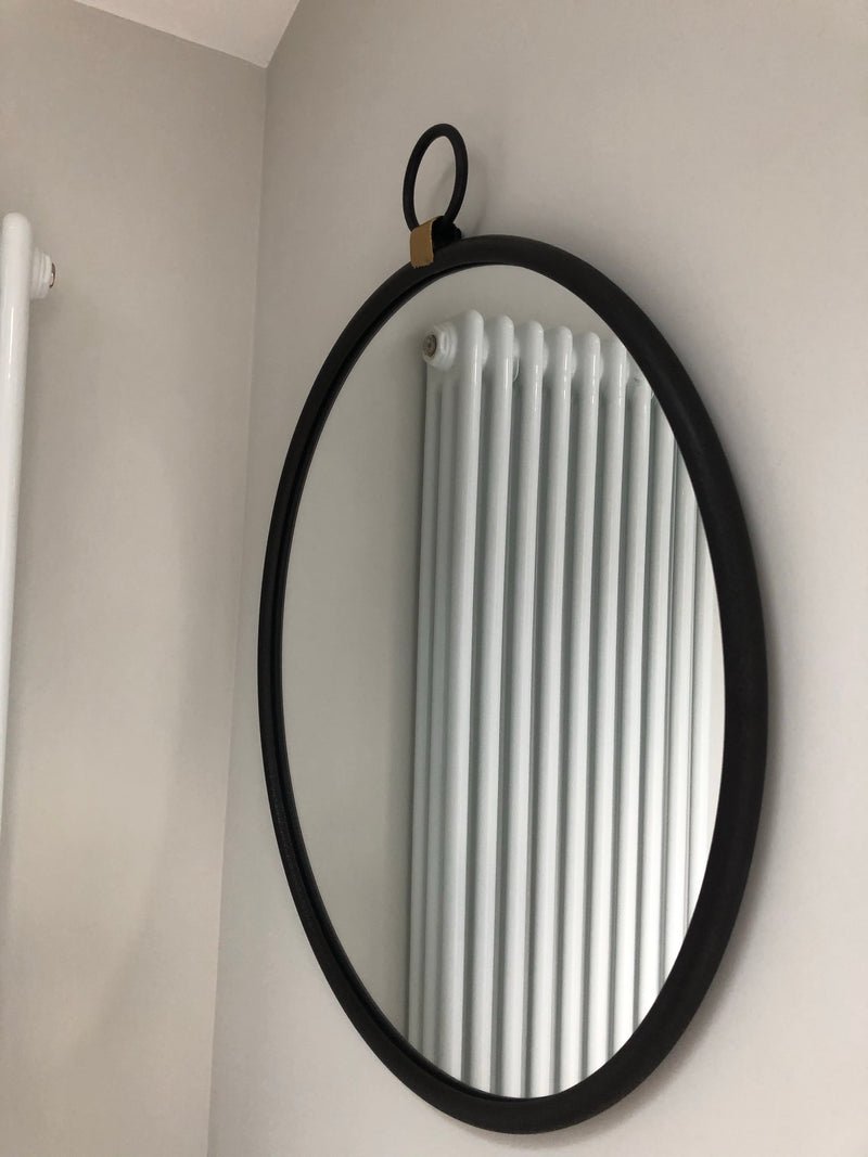 Black round mirror with gold accent and fob detail