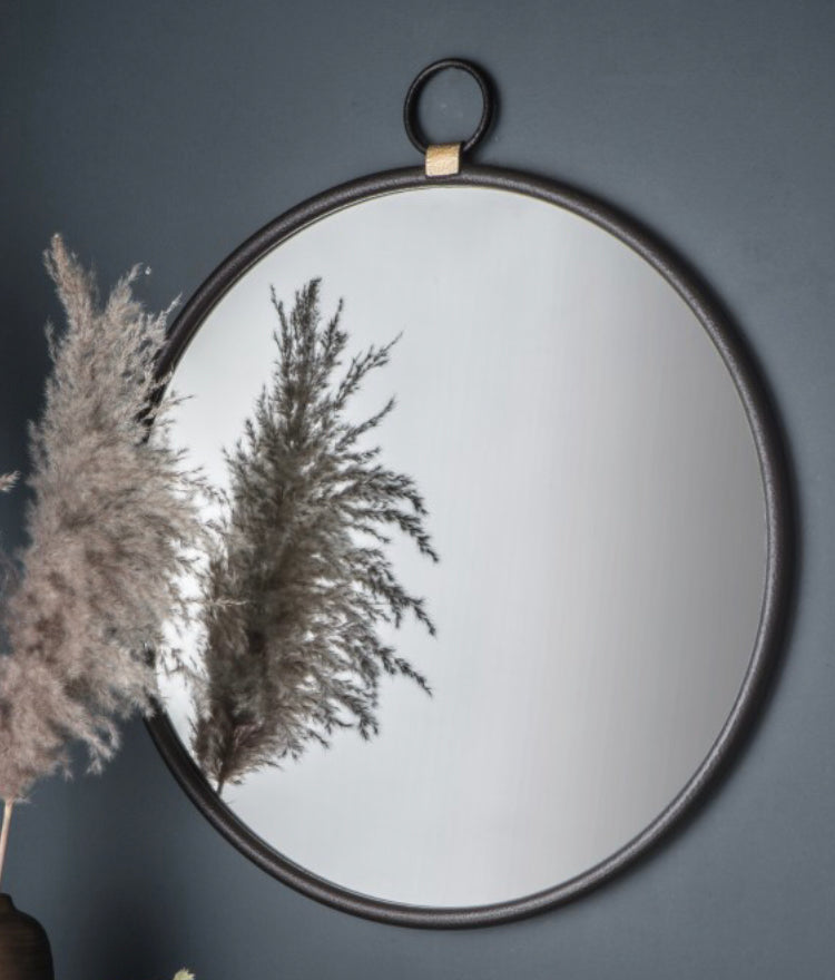 Black round mirror with gold accent and fob detail